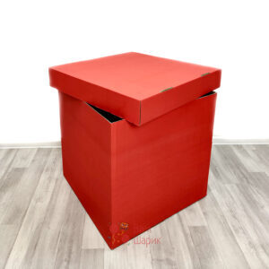 Красная коробка с надписью и черным помпоном